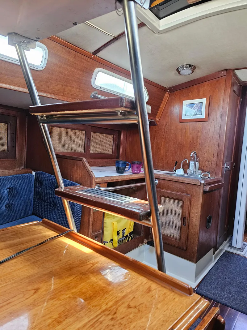 Slide: The Image of Interior of 1984 Schock NY 36 sailboat with wooden cabinetry and ladder. - 40