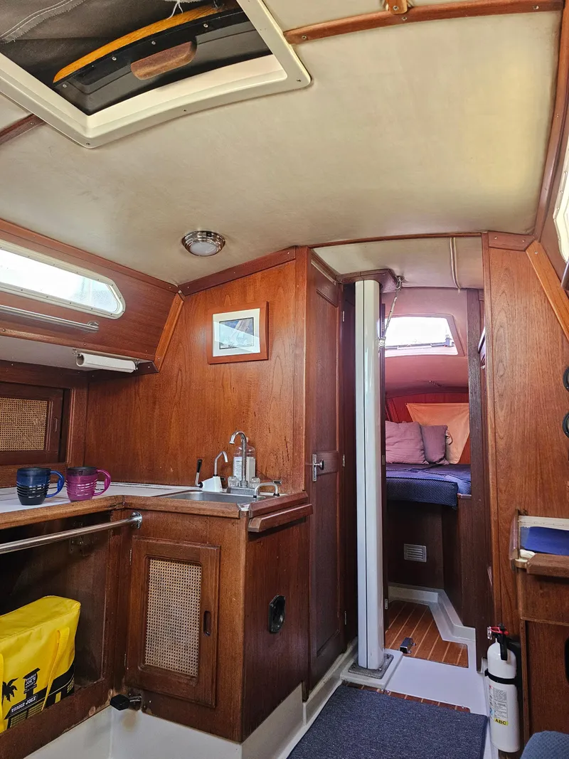 Slide: The Image of Interior of 1984 Schock NY 36 sailboat, featuring wooden cabinetry and cozy sleeping area. - 42