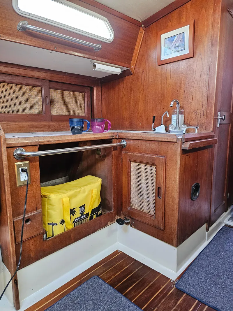 Slide: The Image of 1984 Schock NY 36 yacht interior with wooden cabinetry and compact kitchen area. - 43