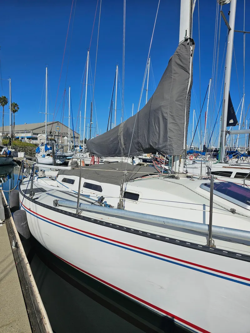 Slide: The Image of 1984 Schock NY 36 sailboat docked in marina, clear blue sky, covered mainsail. - 45