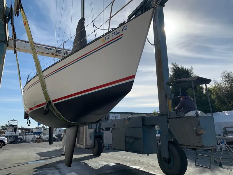 Slide: The Image of 1984 Schock NY 36 sailboat being lifted at a marina. - 47