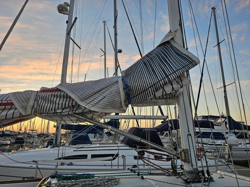 Slide: The Image of Sailboat Schock NY 36, 1984 model, docked at sunset with sails furled. - 5