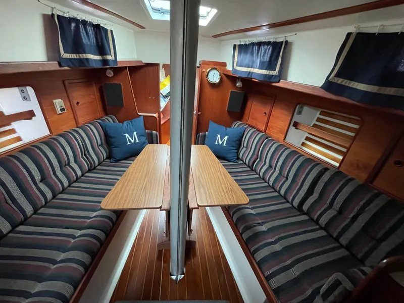 Slide: The Image of Interior of 1980 Hinterhoeller Niagra sailboat with striped seating and wooden accents. - 13
