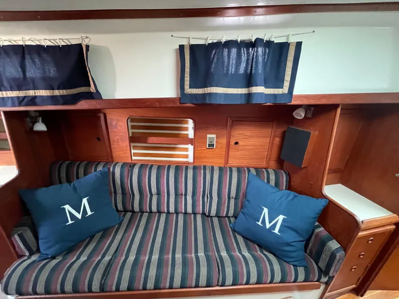 Slide: The Image of Interior of 1980 Hinterhoeller Niagra sailboat with striped sofa and blue pillows. - 14