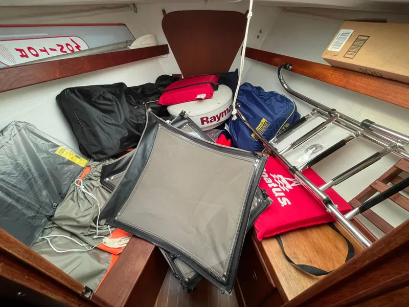 Slide: The Image of 1980 Hinterhoeller Niagra sailboat cabin with various equipment and storage items. - 16