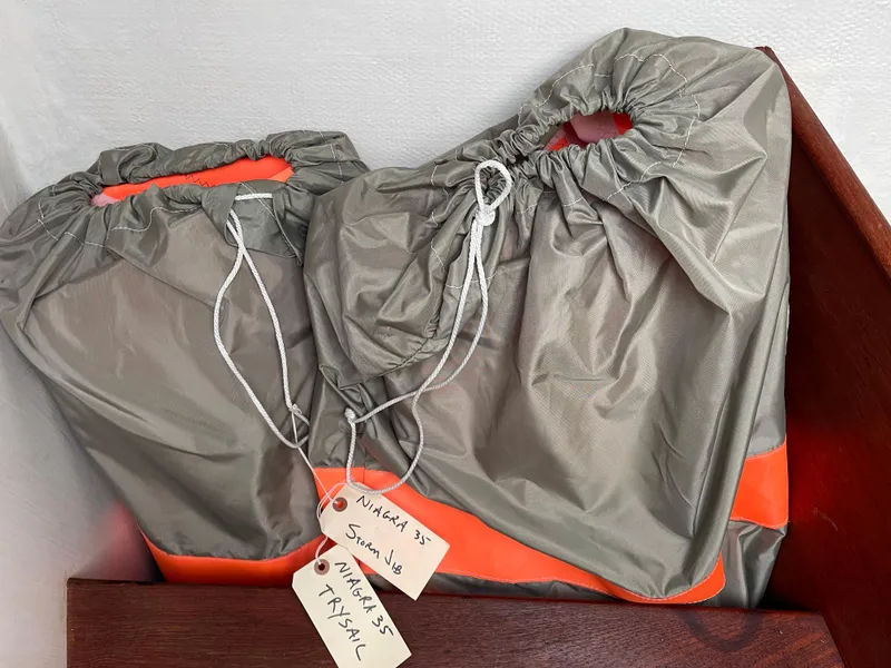 Slide: The Image of Sail bags labeled for Hinterhoeller Niagra 1980, stored on a wooden shelf. - 18