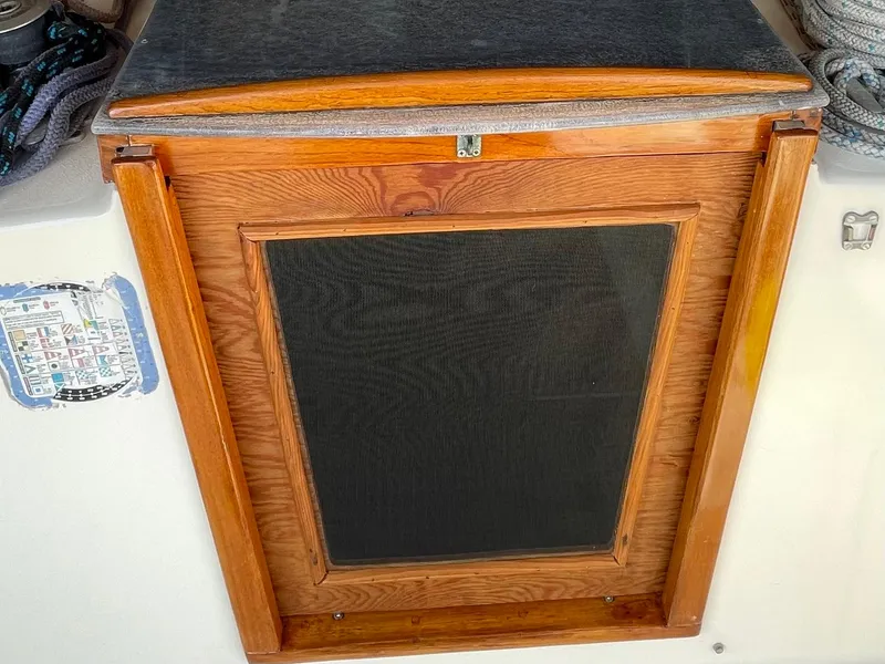 Slide: The Image of Wooden hatch door on a 1980 Hinterhoeller Niagra sailboat, featuring a mesh screen. - 29