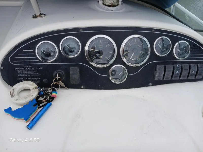 Slide: The Image of Dashboard of a 1997 Sea Ray 240 Sundancer boat with gauges and keys. - 18