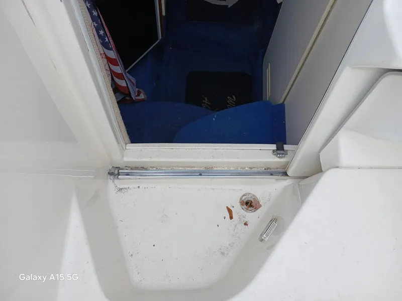 Slide: The Image of 1997 Sea Ray 240 Sundancer cabin entrance with blue interior and American flag detail. - 20