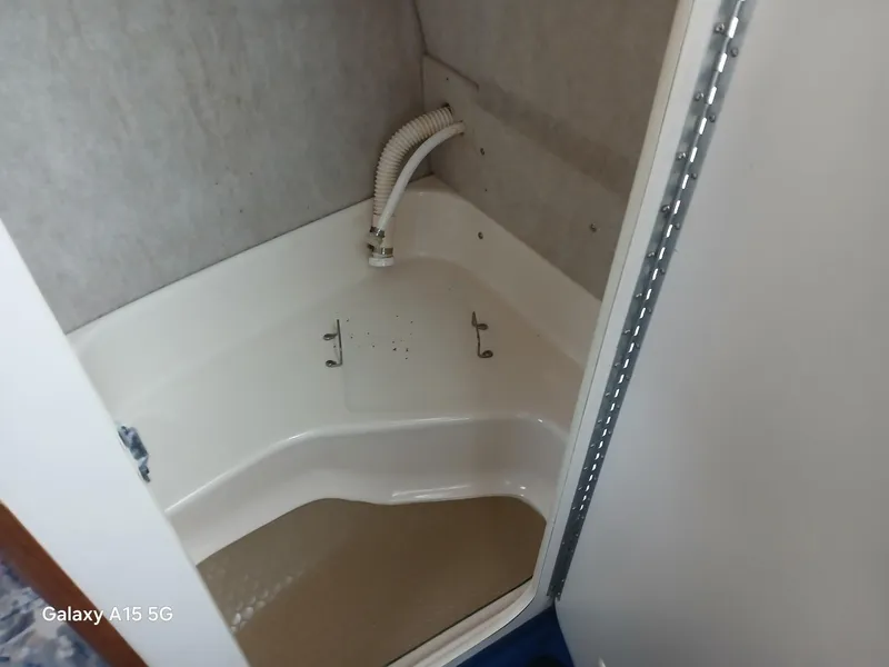 Slide: The Image of 1997 Sea Ray 240 Sundancer boat interior, featuring a compact shower area. - 31