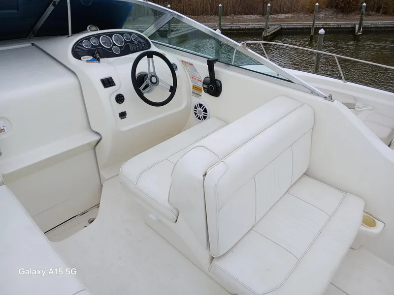 Slide: The Image of 1997 Sea Ray 240 Sundancer boat interior with steering wheel and seating. - 16