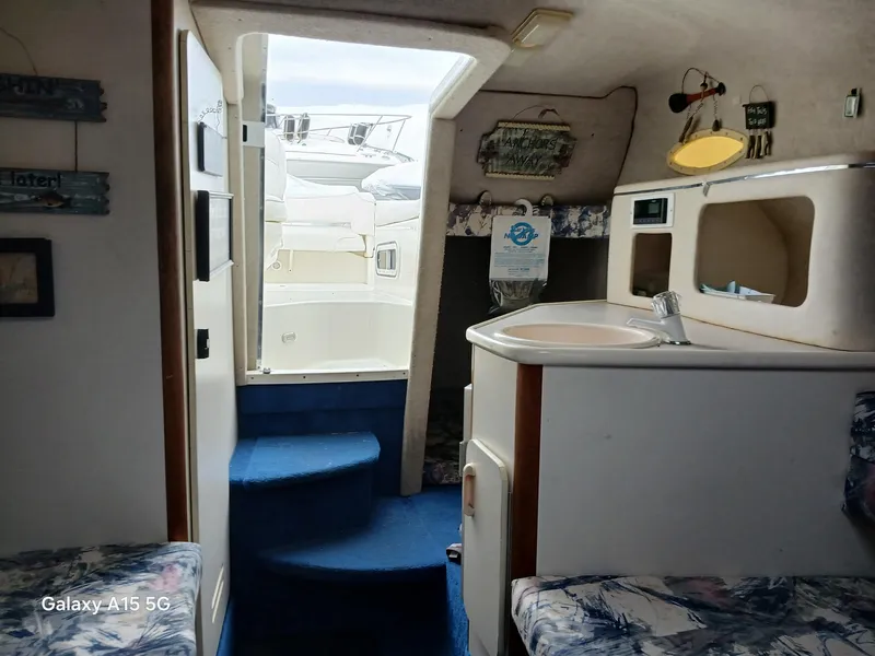 Slide: The Image of Interior of 1997 Sea Ray 240 Sundancer boat with kitchenette and seating area. - 25