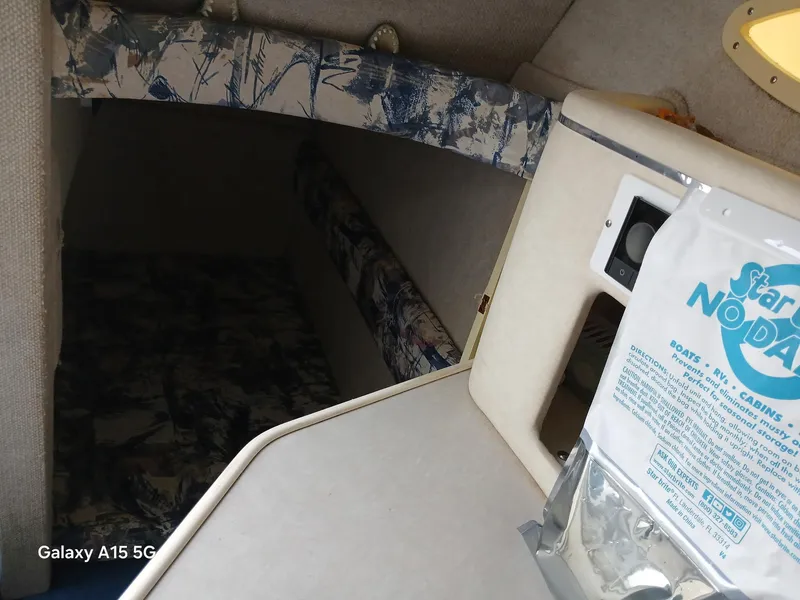 Slide: The Image of 1997 Sea Ray 240 Sundancer cabin interior with patterned upholstery and storage area. - 29