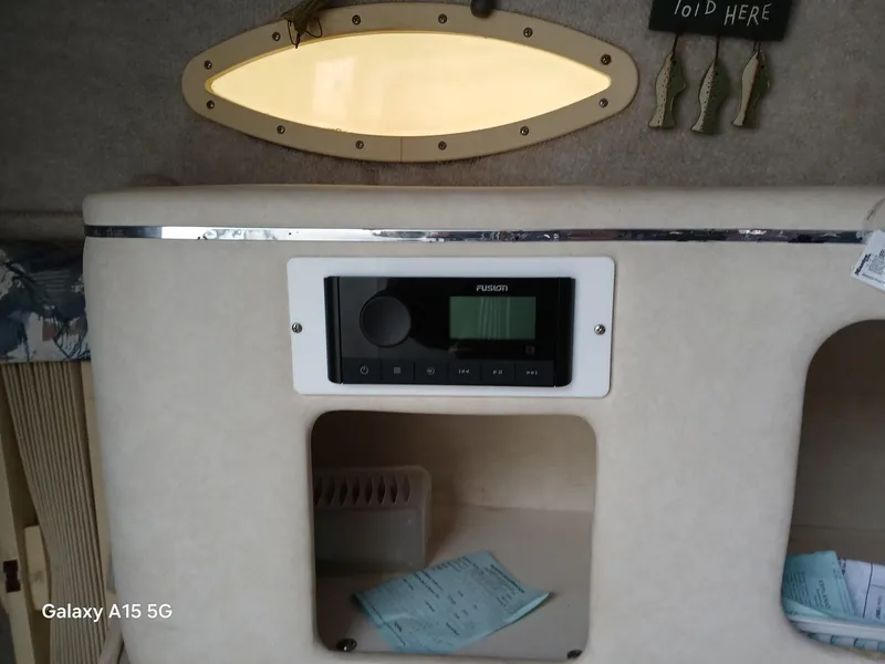 Slide: The Image of 1997 Sea Ray 240 Sundancer cabin interior with audio system and storage compartment. - 28