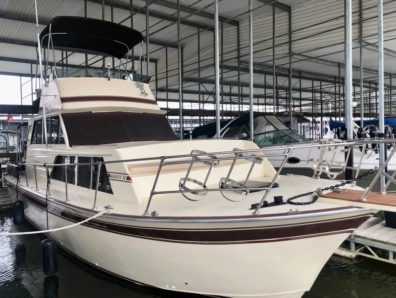 Slide: The Image of 1985 Marinette 32 Sedan Flybridge docked in a covered marina. - 14