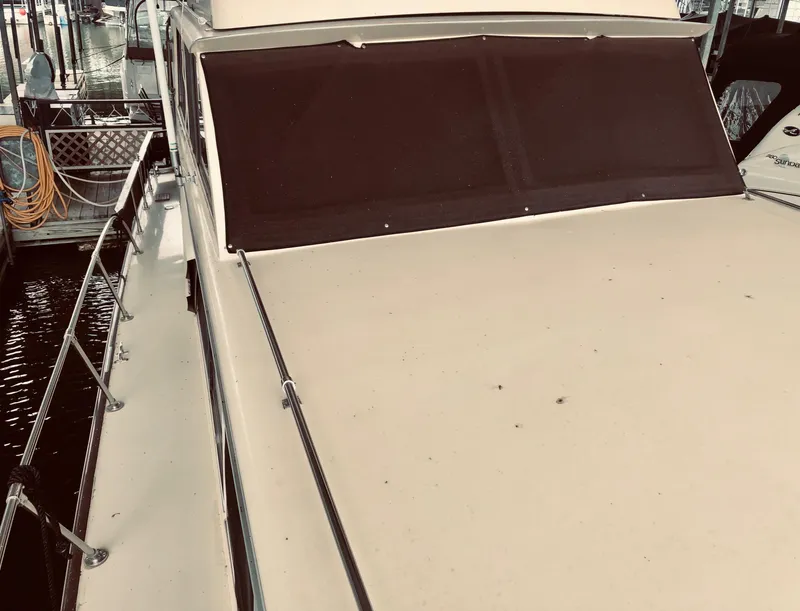 Slide: The Image of 1985 Marinette 32 Sedan Flybridge boat with covered windshield, docked at marina. - 17