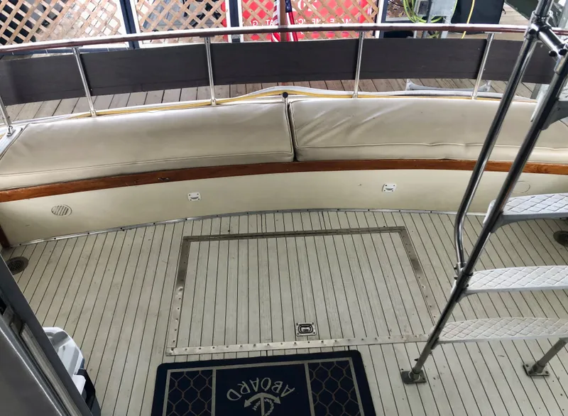 Slide: The Image of 1985 Marinette 32 Sedan Flybridge deck with cushioned seating and ladder. - 21