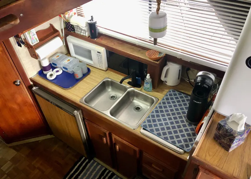 Slide: The Image of 1985 Marinette 32 Sedan Flybridge kitchen with dual sinks, microwave, and appliances. - 25