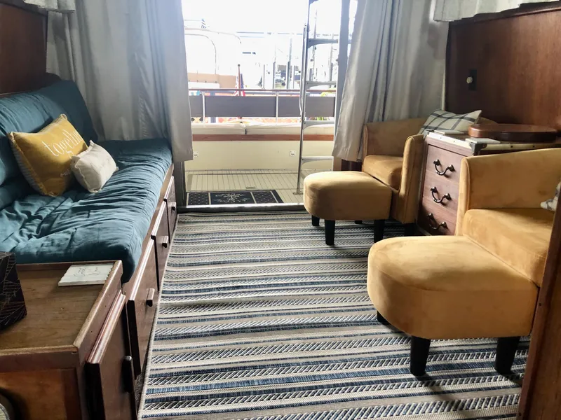 Slide: The Image of Interior of 1985 Marinette 32 Sedan Flybridge with cozy seating and striped rug. - 26