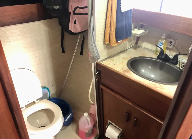 Slide: The Image of 1985 Marinette 32 Sedan Flybridge bathroom with sink, toilet, and storage. - 27