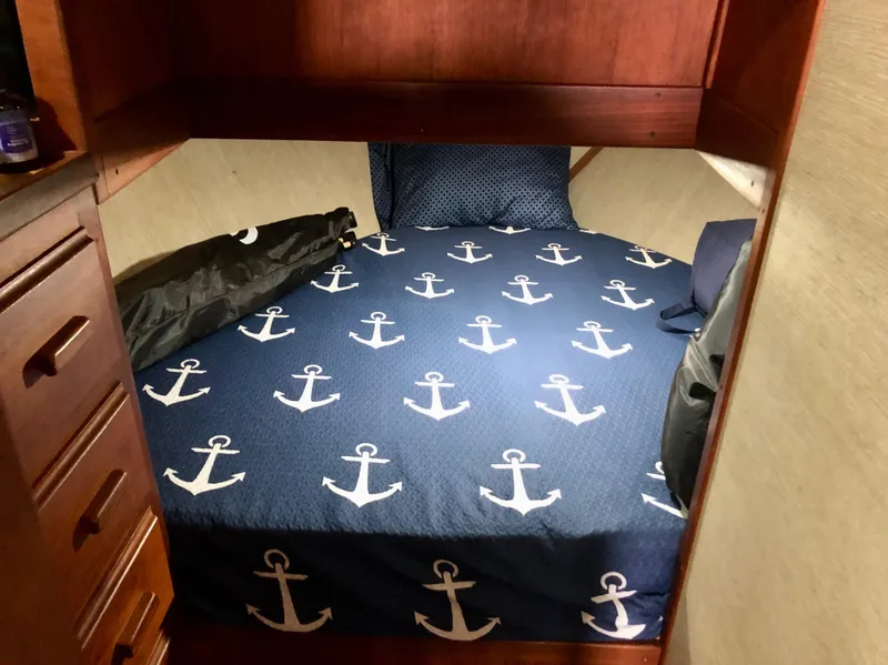 Slide: The Image of Cozy cabin bed with anchor-themed bedding in 1985 Marinette 32 Sedan Flybridge. - 28
