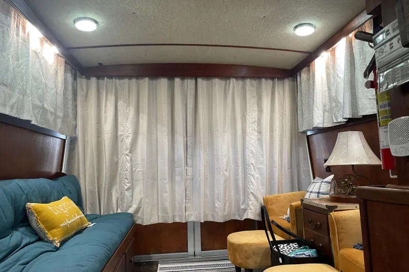 Slide: The Image of Interior of 1985 Marinette 32 Sedan Flybridge with cozy seating and curtains. - 6