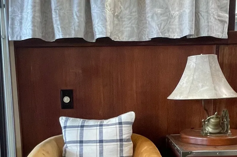 Slide: The Image of Interior of 1985 Marinette 32 Sedan Flybridge with chair, plaid pillow, and lamp. - 7