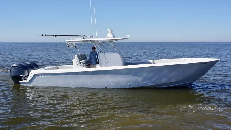 Slide: The Image of 2023 Contender 35 ST boat on calm water, featuring dual outboard motors. - 12