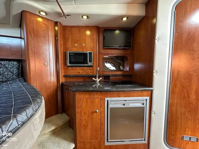Slide: The Image of Interior of 2013 Rinker 310 Express Cruiser with kitchen and sleeping area. - 10