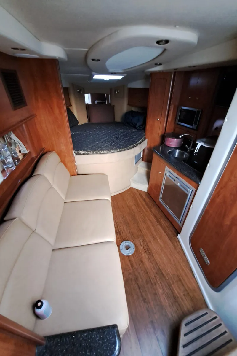 Slide: The Image of Interior of 2013 Rinker 310 Express Cruiser with sofa and kitchenette. - 15