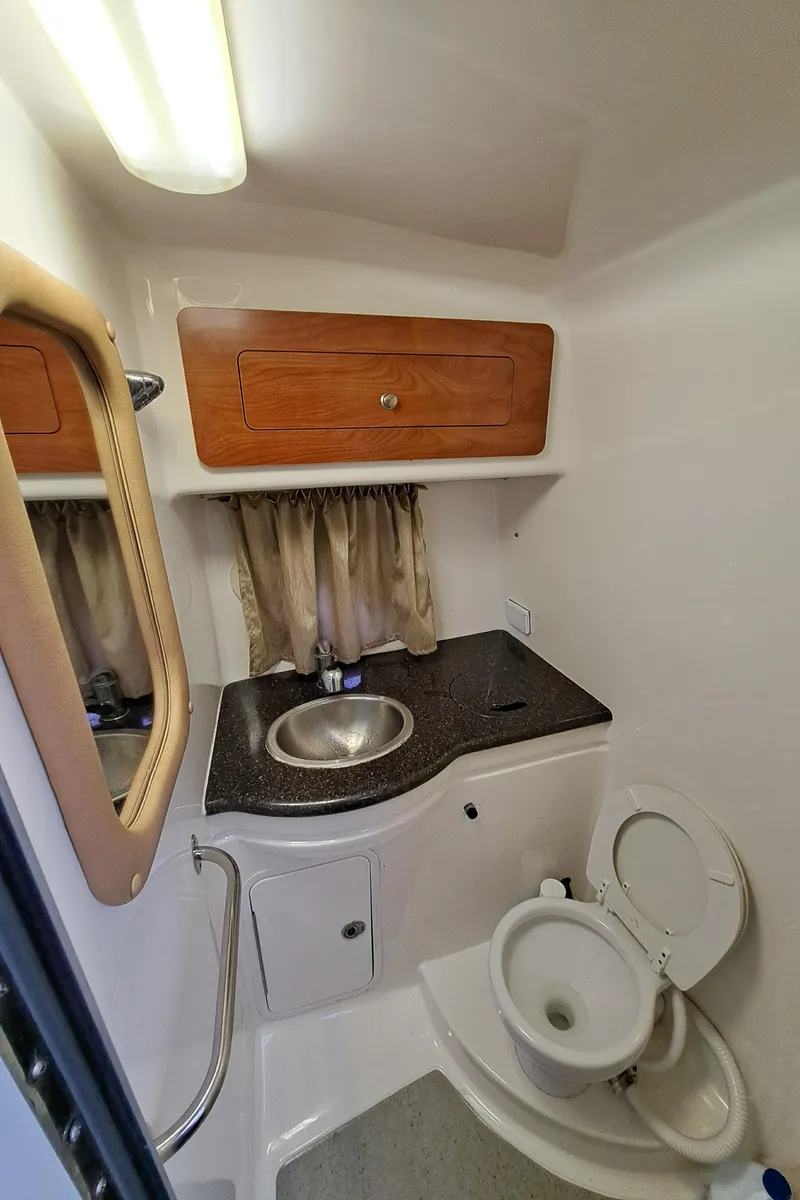 Slide: The Image of 2013 Rinker 310 Express Cruiser bathroom with sink and toilet. - 18