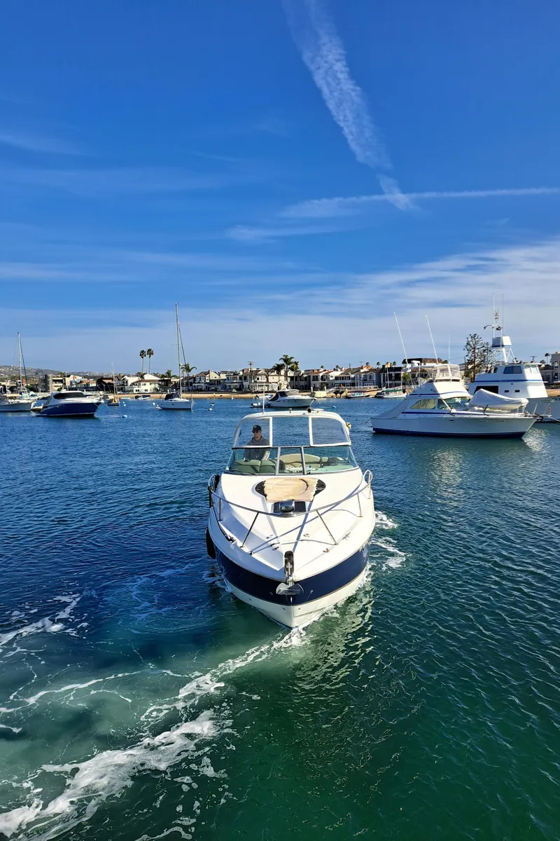 Slide: The Image of 2013 Rinker 310 Express Cruiser anchored on calm waters. - 4