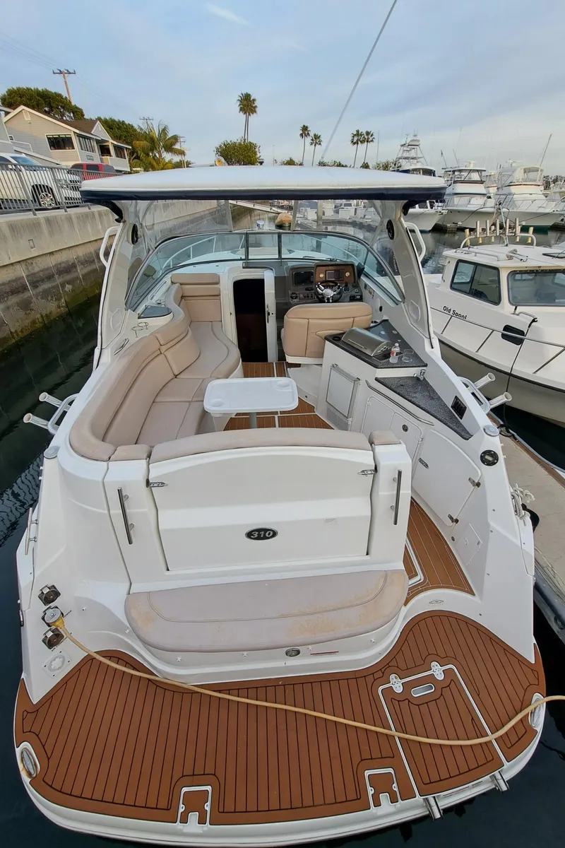 Slide: The Image of 2013 Rinker 310 Express Cruiser docked, featuring luxurious interior. - 6
