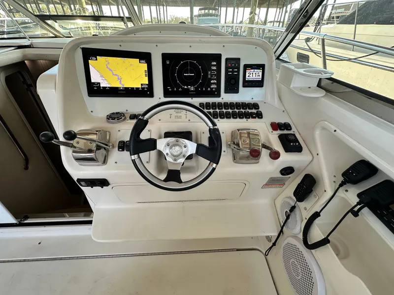 Slide: The Image of 1997 Sea Ray 370 Express Cruiser helm with modern navigation equipment and steering wheel. - 10