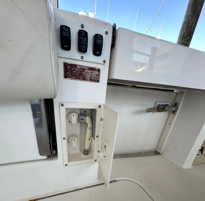Slide: The Image of 1997 Sea Ray 370 Express Cruiser deck area with control panel and open hatch. - 21