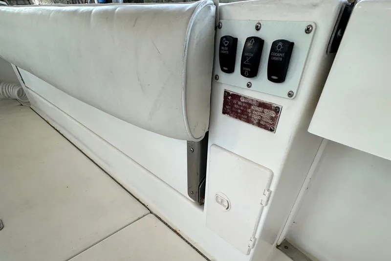 Slide: The Image of 1997 Sea Ray 370 Express Cruiser control panel with switches and open compartment. - 22