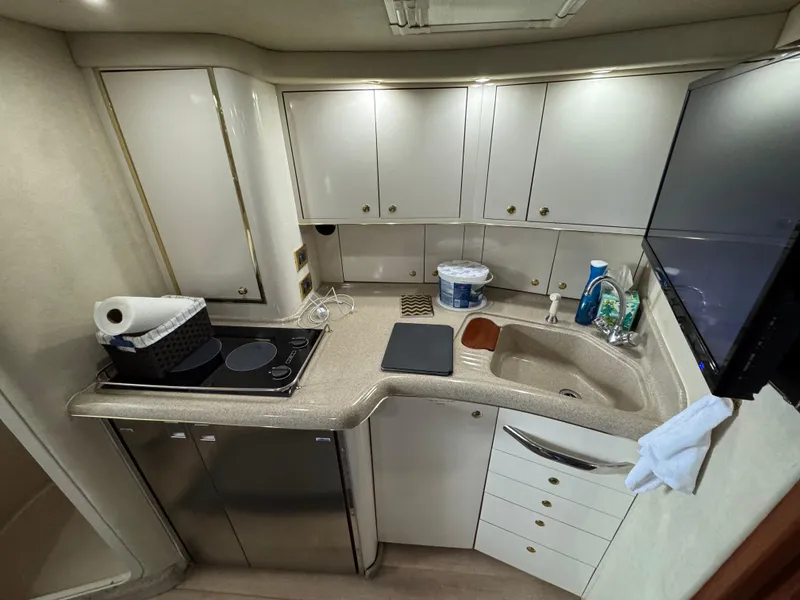 Slide: The Image of 1997 Sea Ray 370 Express Cruiser kitchen with modern appliances and ample storage. - 38