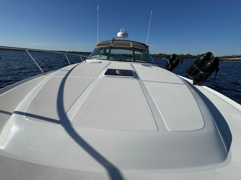 Slide: The Image of 1997 Sea Ray 370 Express Cruiser on calm water, showcasing sleek deck design. - 41
