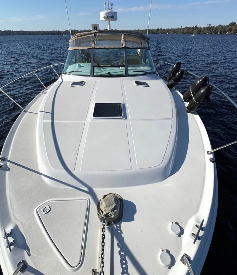 Slide: The Image of 1997 Sea Ray 370 Express Cruiser on calm water, showcasing sleek deck design. - 42