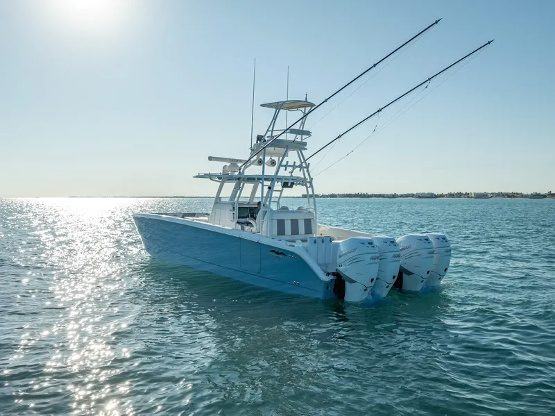 Slide: The Image of 2023 Invincible 37 Catamaran on calm water, featuring dual outboard motors and fishing rods. - 26