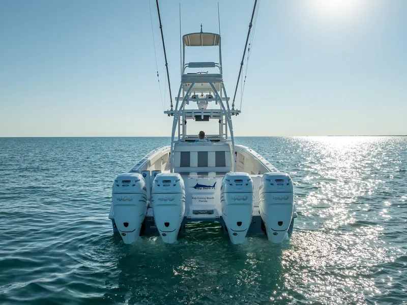 Slide: The Image of 2023 Invincible 37 Catamaran on open water, rear view with four engines. - 28