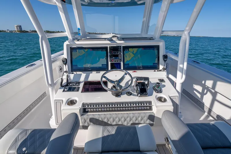 Slide: The Image of 2023 Invincible 37 Catamaran helm with dual screens and modern controls on open water. - 34