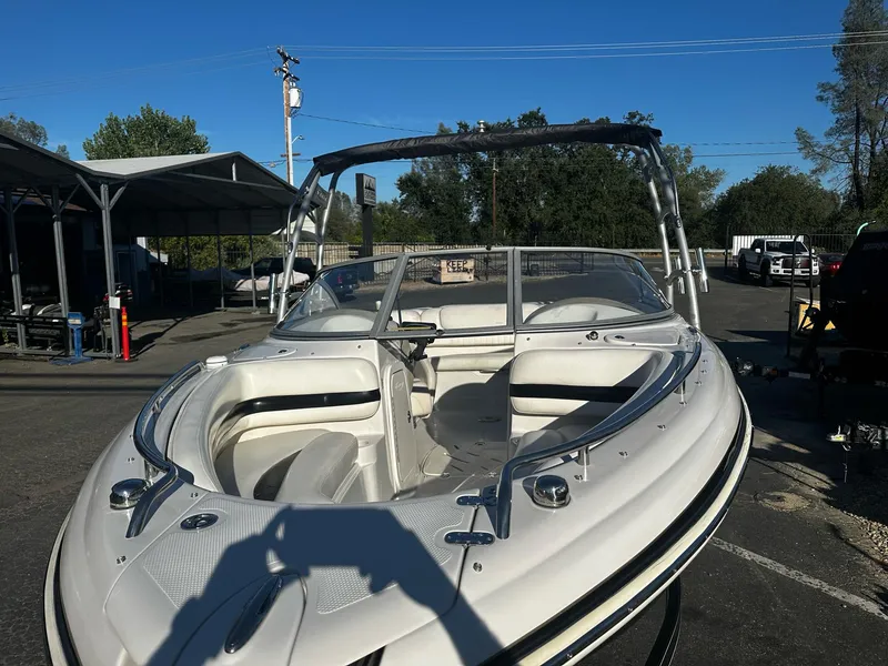 Slide: The Image of 2006 Tahoe 215 I/O boat with open bow seating, parked outdoors. - 4