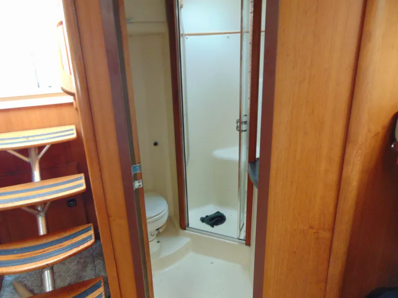 Slide: The Image of 2000 Luhrs T-360SX/SF yacht interior with wooden stairs and compact bathroom. - 13