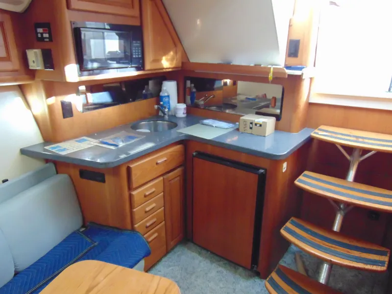 Slide: The Image of 2000 Luhrs T-360SX/SF yacht interior with kitchenette, seating, and stairs. - 14