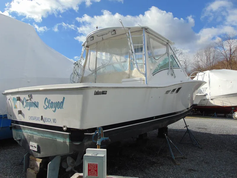 Slide: The Image of 2000 Luhrs T-360SX/SF boat on dry dock under a partly cloudy sky. - 5