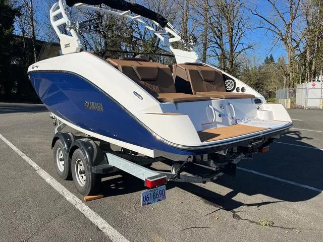 Slide: The Image of 2024 Yamaha Boats 222S on trailer, blue and white design, parked outdoors. - 3