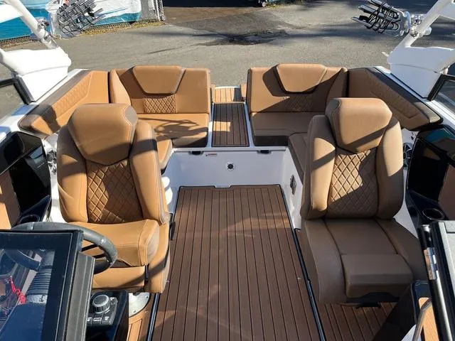 Slide: The Image of 2024 Yamaha Boats 222S interior with tan leather seating and wood-style flooring. - 6