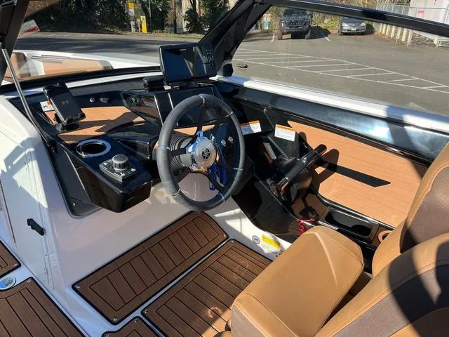 Slide: The Image of 2024 Yamaha Boats 222S interior with modern dashboard and brown seating. - 8