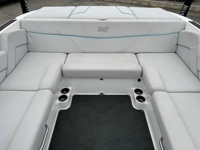 Slide: The Image of 2019 MasterCraft NXT22 boat interior with white seating and black flooring. - 17